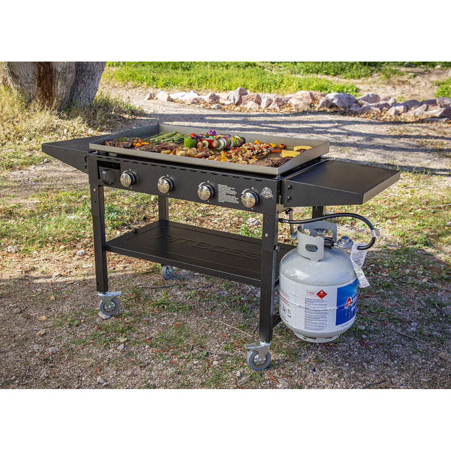 lifestyle photo of griddle hooked to gas and cooking meat and veggies