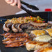 Close up of tongs flipping breakfast sausage on the griddle. top.