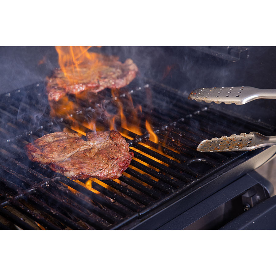 steaks searing in open flame on cooking grate