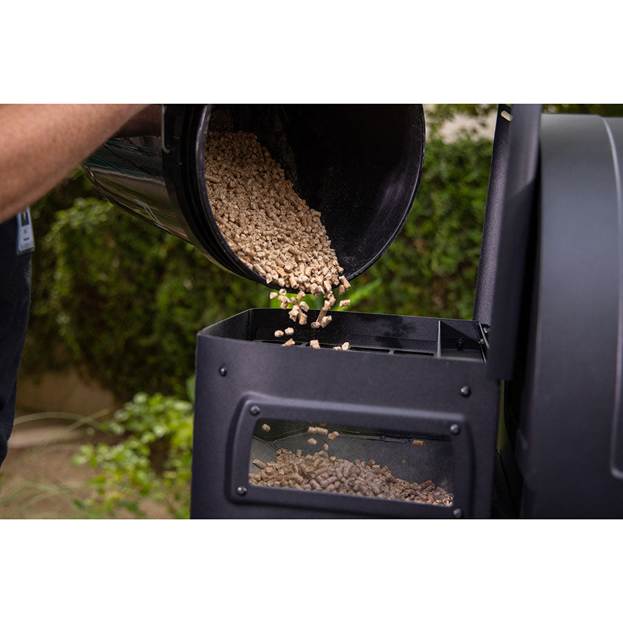 pellets being poured into top of hopper from black bucket