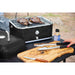 lifestyle_1, All back with silver accents and small Pit Boss logo. Pictured on outdoor table with meat grilling