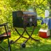 Pit Boss Mahogany 260 Portable Wood Pellet Grill on a camp ground with smoke steaming out of it.