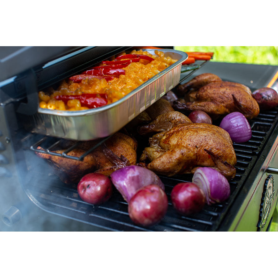 meats and veggies being cooked on both racks of grill