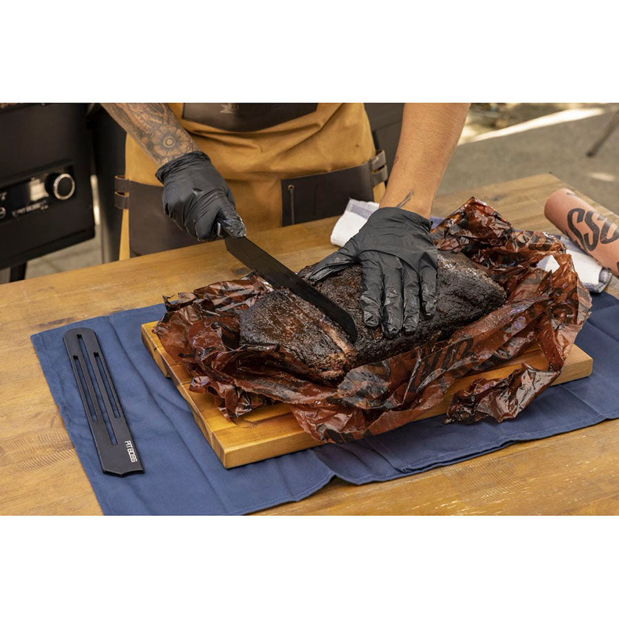 Close up of meat being cut with Pit Boss knives outside.