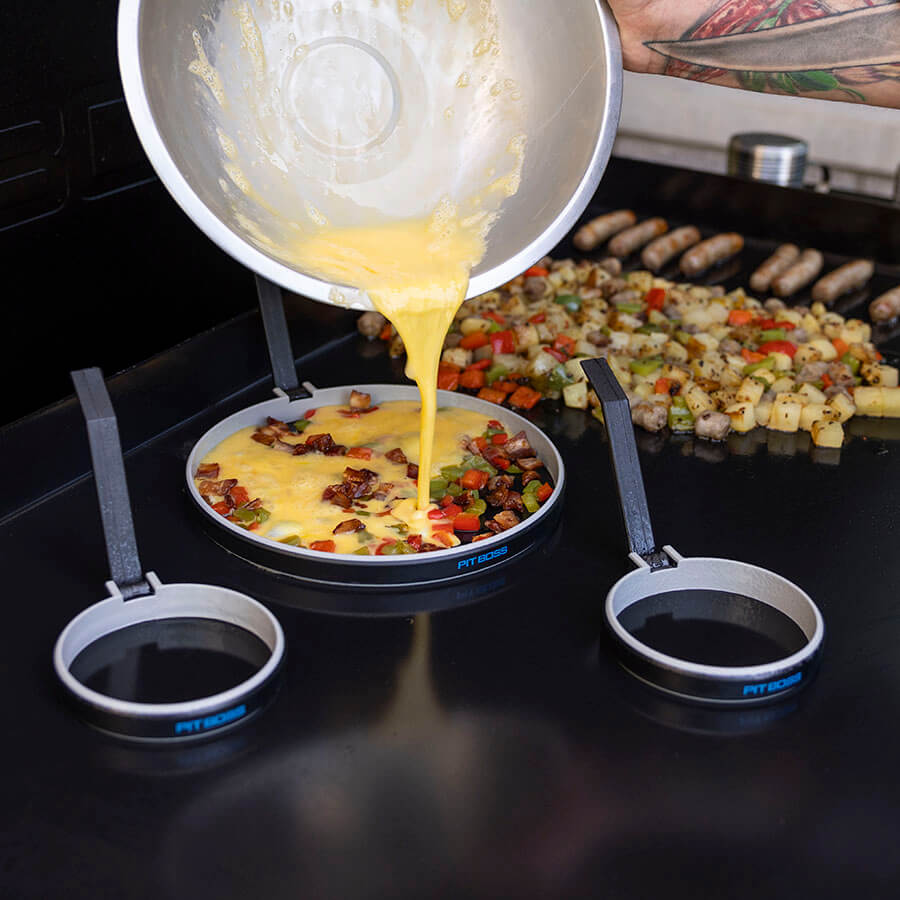 Egg omelet being pored into a Pit Boss mold on the griddle.