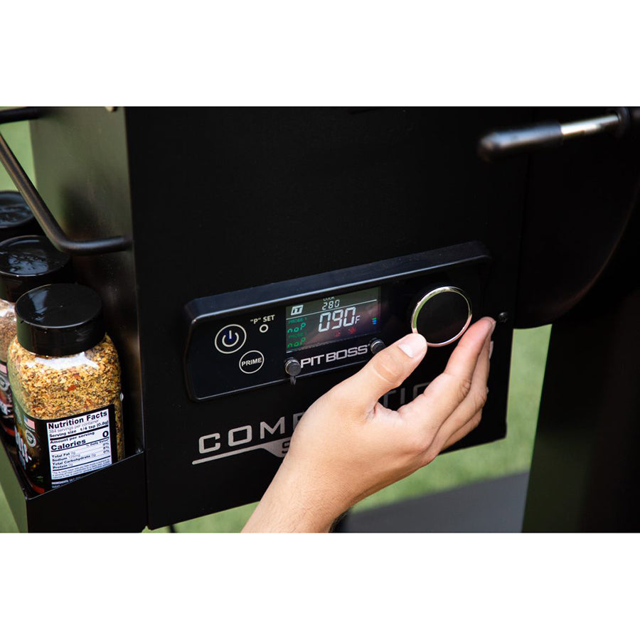 hand adjusting the digital control board on grill hopper