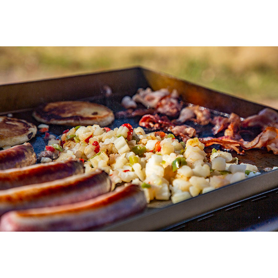 Up close of pancakes, sausage, bacon and hashbrowns being grilled on the 3-burner griddle.