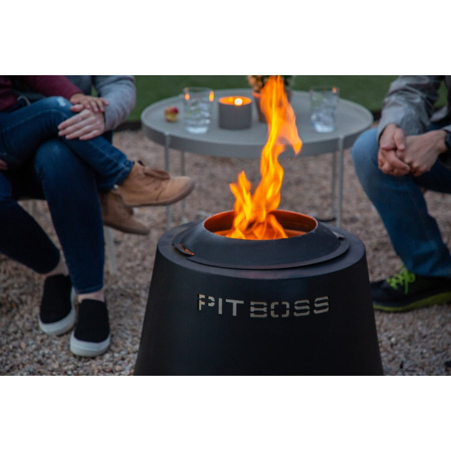 lifestyle_2, All black fire pit with silver lettering engraved "Pit Boss" logo. Shot of people gathered around the fire pit