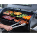 lifestyle_2, Using tongs to pick up grilled meat off of grill racks while meat and veggies cook