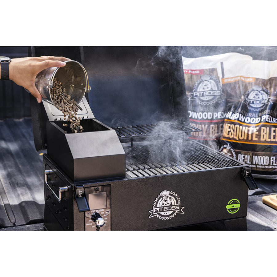 Close view of the portable grill being fueled by pit bosses wood pellets in the back of a truck.