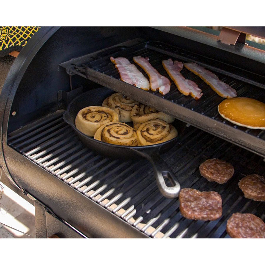 cinnamon rolls cooking in cast iron skillet inside grill