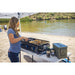 Women using the 3-Burner tabletop griddle at a lake cooking meats and veggies with the Pit Boss spices.