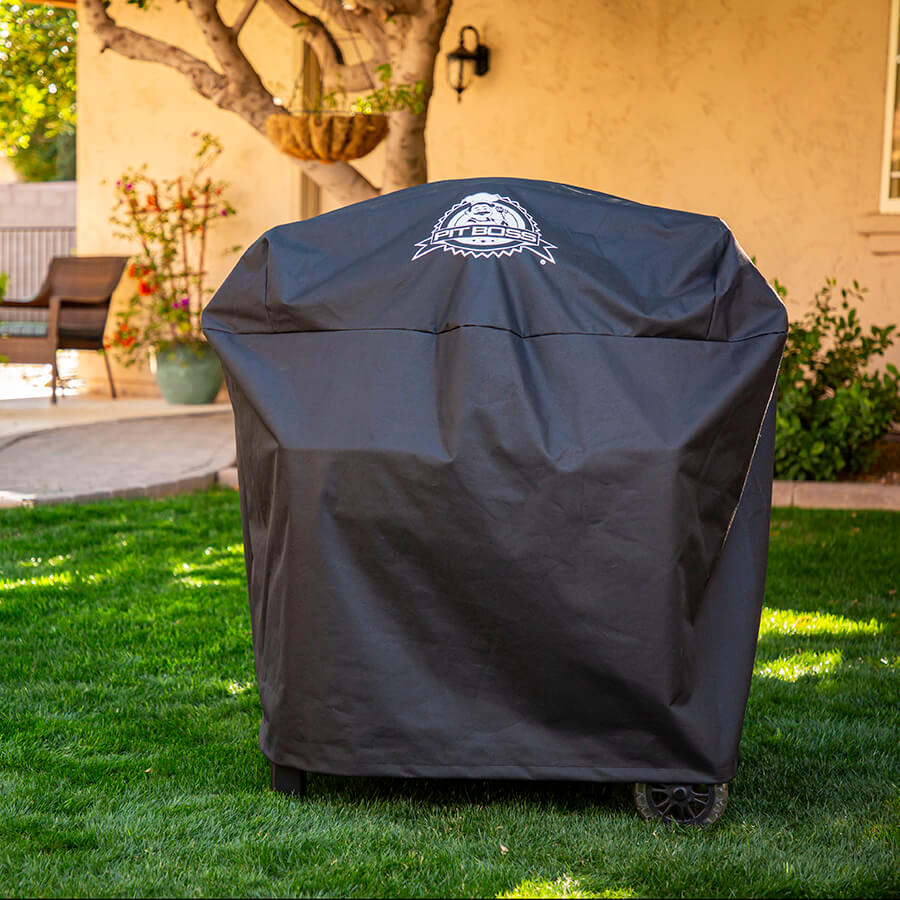 Pit Boss barbecue cover with Pit Boss logo large in middle of cover. Grill and cover outside.