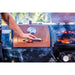 lifestyle_3, Black grill with brownish-orange/copper and silver accents with pit boss logo/ Close up shot of one grill hood open and cooking while other is closed