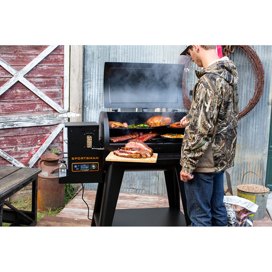 meat and veggies grilling on grill in front of shed