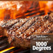 Up close of steak being seared in open flame on grill rack