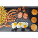 Over the head shot of eggs, bacon, hashbrowns, and pancakes cooking on the griddle