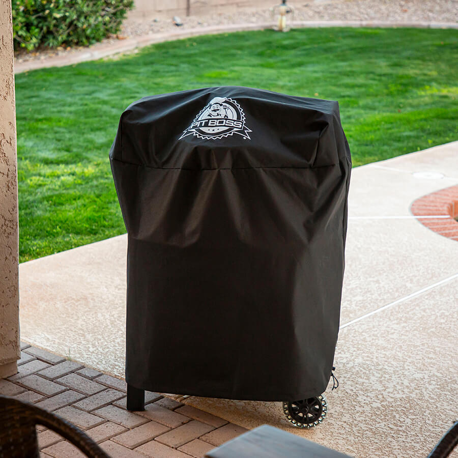 Pit Boss barbecue cover with Pit Boss logo large in middle of cover. Grill and cover outside.