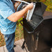 lifestyle_6, Black smoker with small Pit boss logo on transparent door and engraved "Pro Series" on front. Shot of man pouring wood pellets into back of smoker