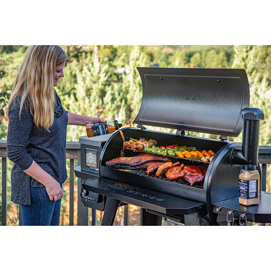 Spices being poured on meat, food on grill