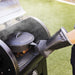 Glove on hand as it is cooking on grill with pot.