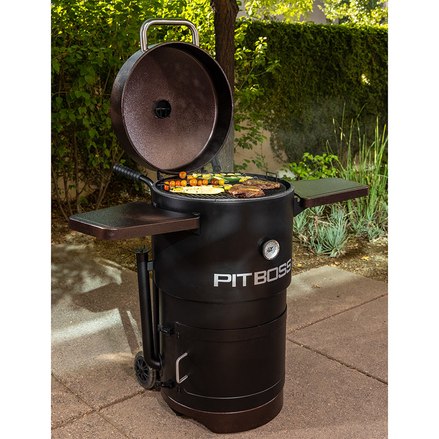 pit boss champion charcoal barrel smoker grill mahogany studio shot. food cooking on barrel smoker, full wide shot