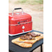 lifestyle_1, Red grill with black and silver accents and a small Pit Boss logo. Pictured on outdoor table with grilled meat