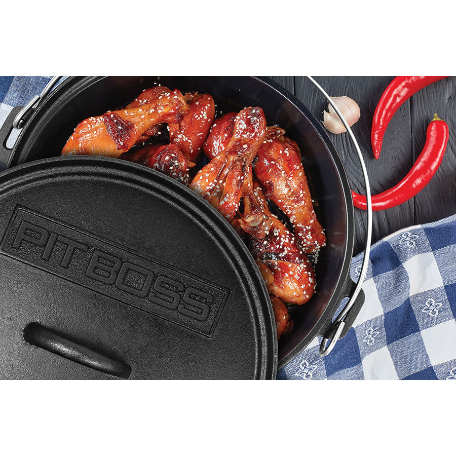 lifestyle_3, Sesame wings in dutch oven with lid partially off sitting on wood table with chiles and garlic on the side