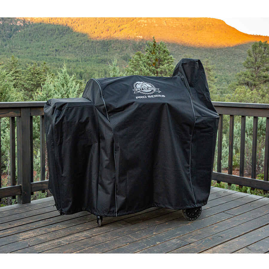 lifestyle_1, Black grill cover with white pit boss pro series logo. Grill covered with cover on porch overlooking scenery