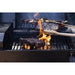 Up close view of meat searing on an open flame on the first grill rack.