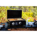 griddle with food sitting on picnic table with other Pit Boss grilling accessories