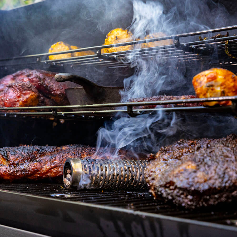 Smoke tube in main grilling rack with meats and veggies on all three grilling racks.