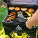 Food on grill with tongs in a backyard.