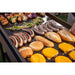 Close up of meats and veggies being cooked on the griddle.